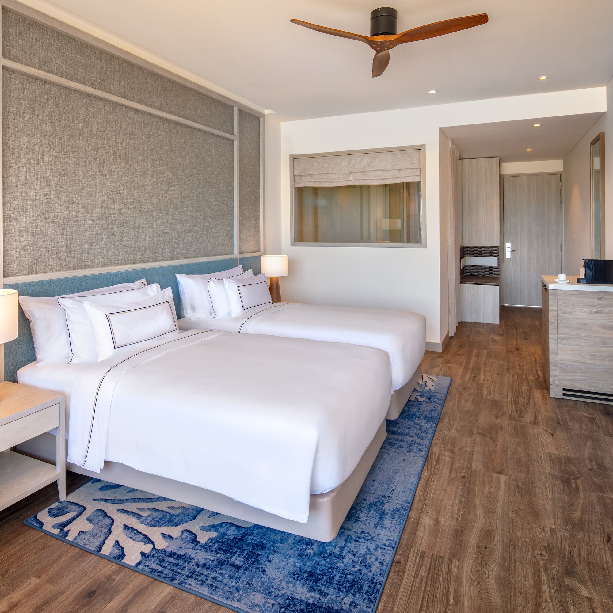 a room with two beds and a ceiling fan