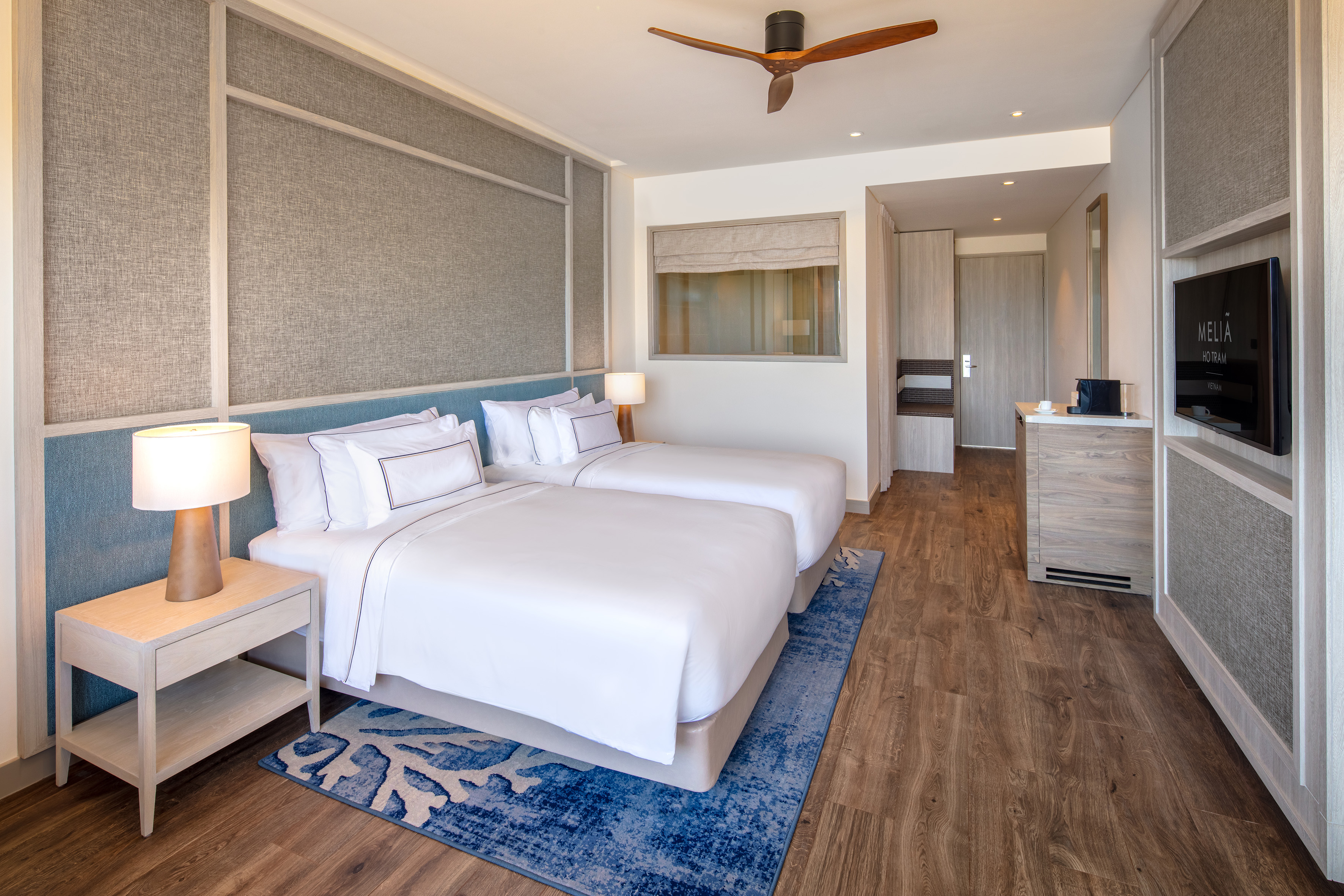 a room with two beds and a ceiling fan