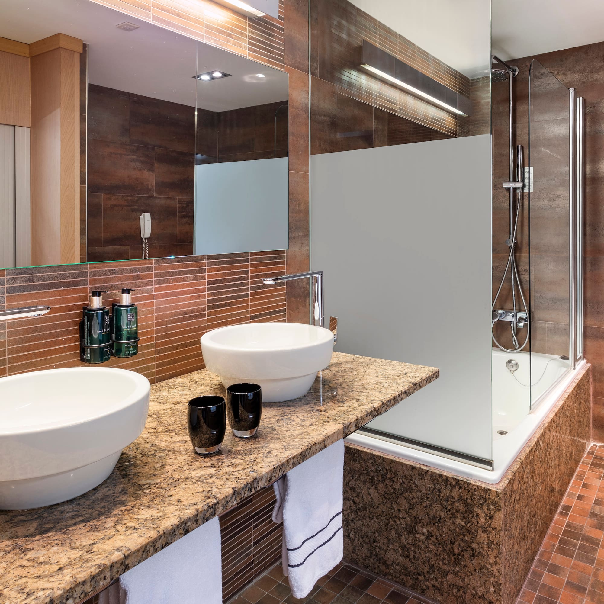 a bathroom with a shower and two sinks