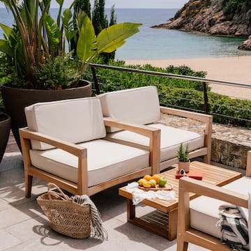 a chair and table on a patio overlooking a beach