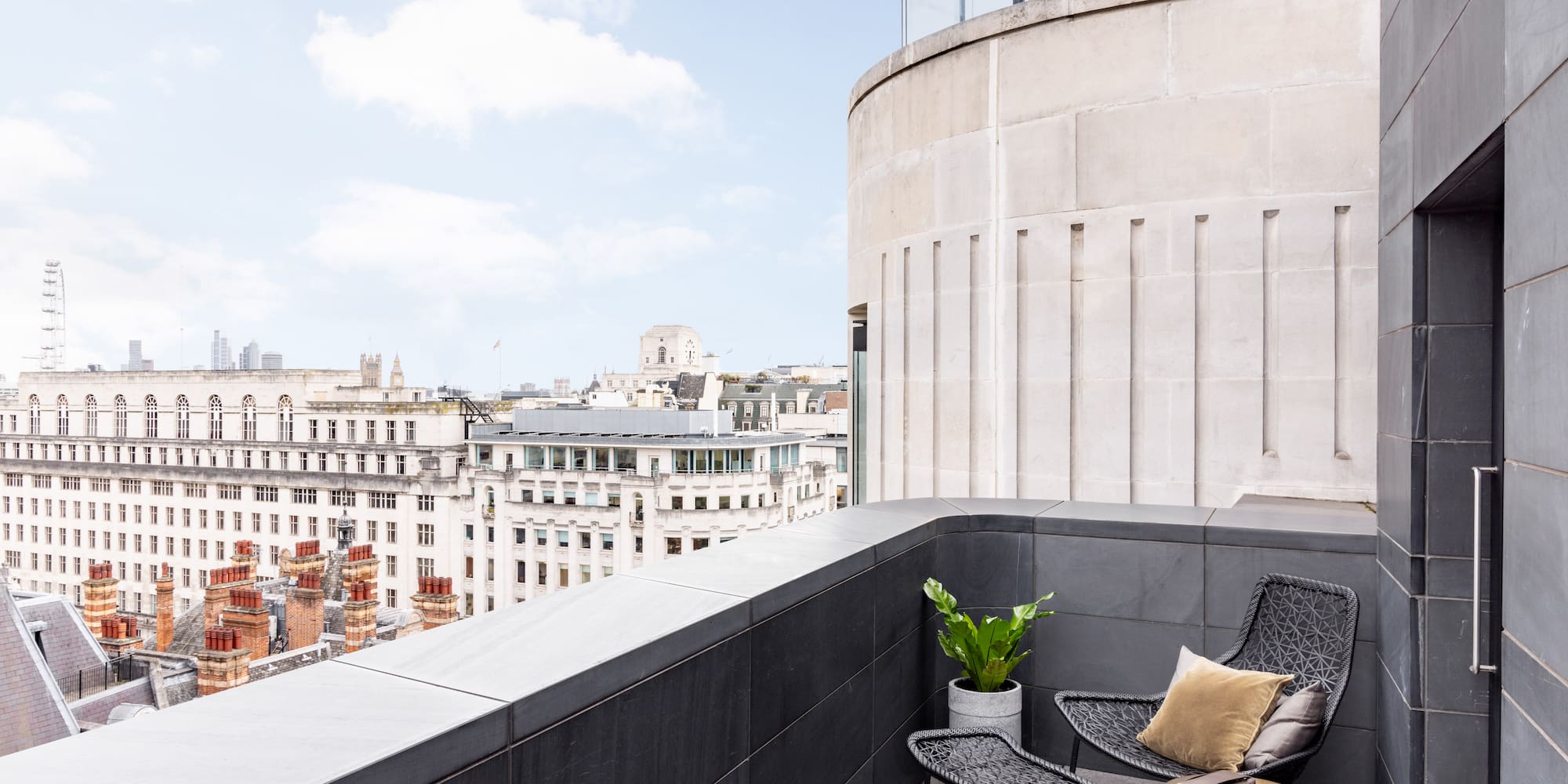 a chair and table on a balcony overlooking a city