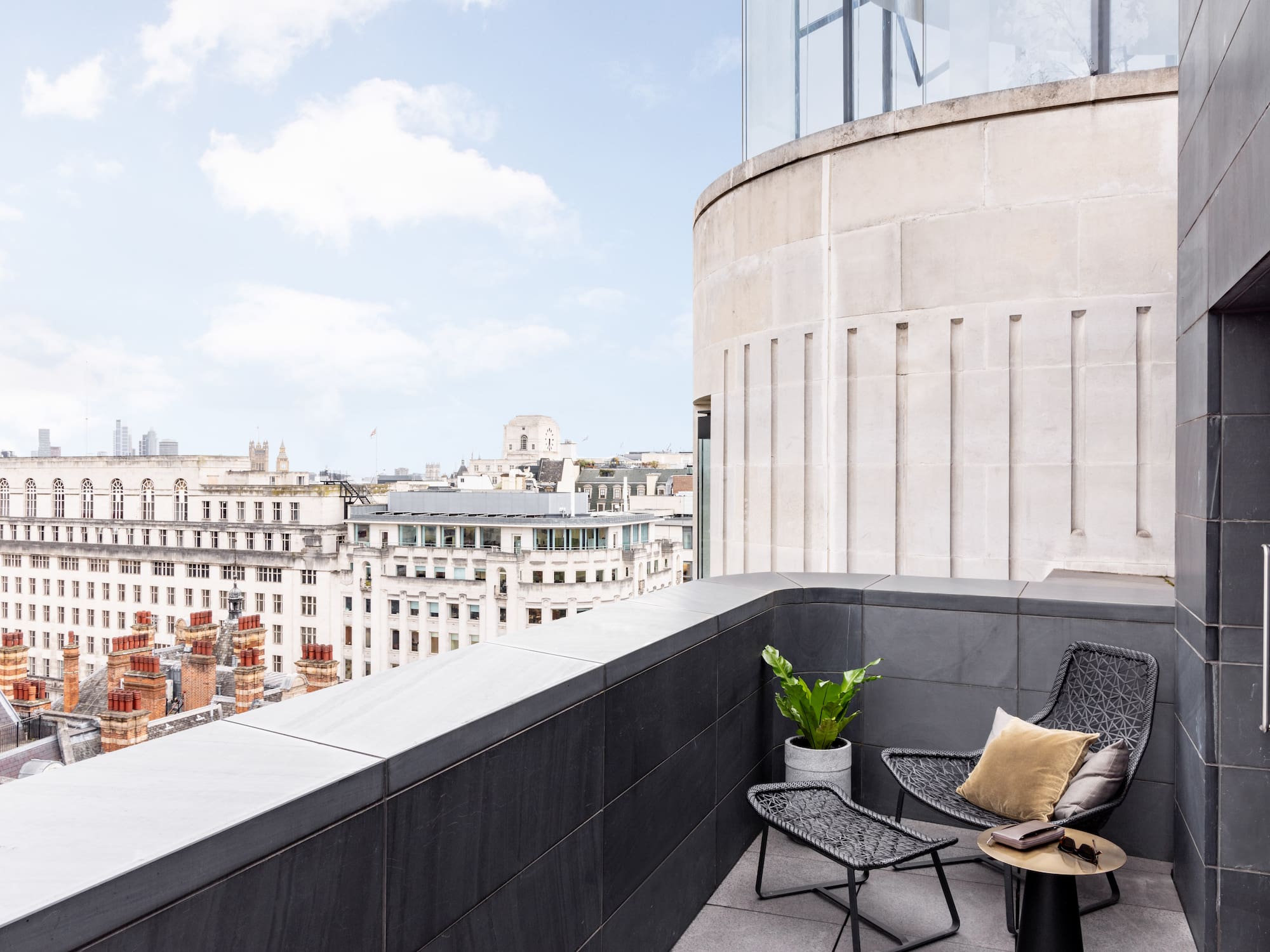 a chair and table on a balcony overlooking a city