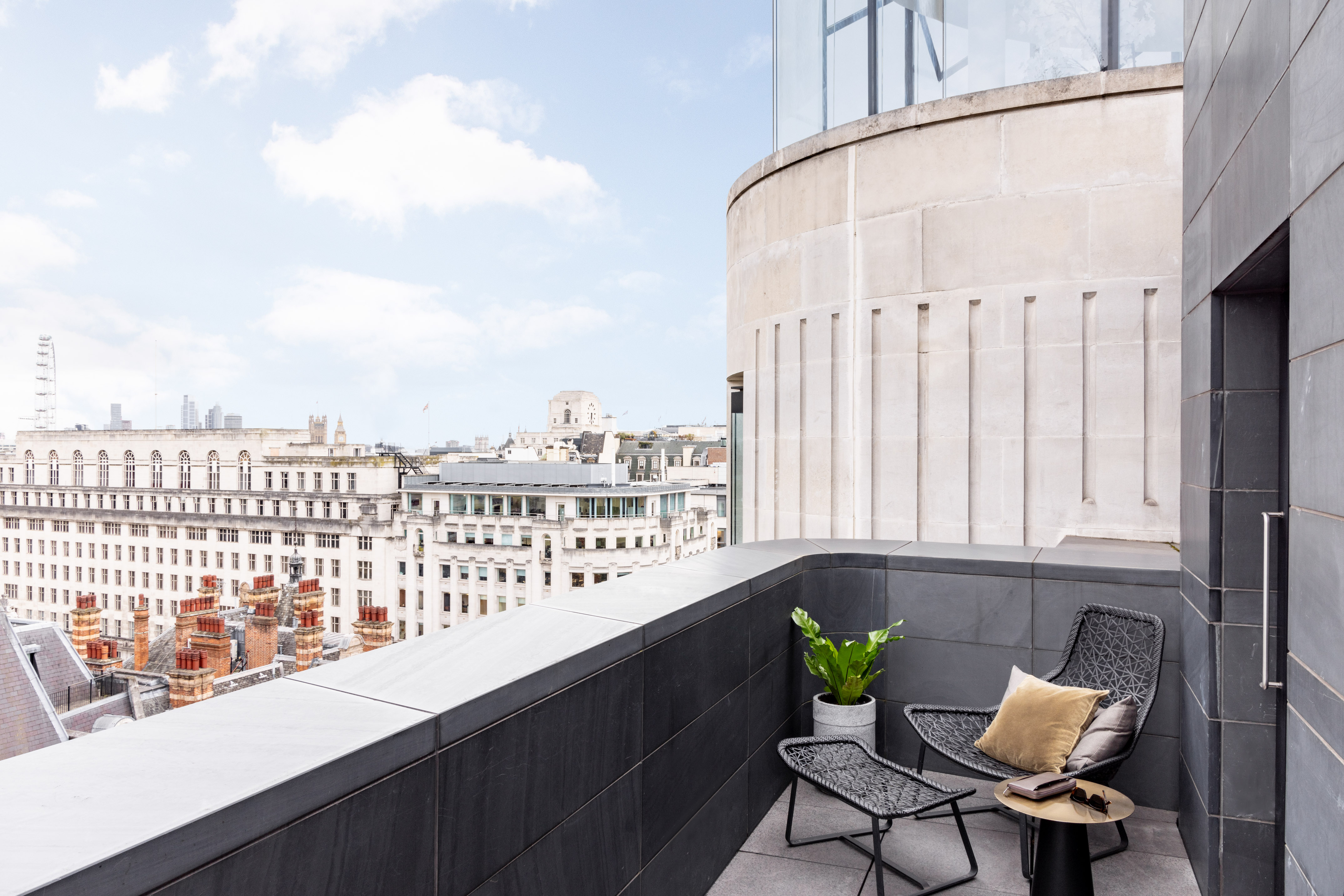 a chair and table on a balcony overlooking a city
