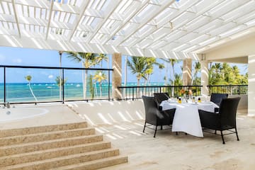 a table set up on a patio with a view of the ocean