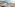 Innside hotel, coastal resort town, beach, bay, and mountains under clear sky.