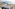 Innside hotel, coastal resort town, beach, bay, and mountains under clear sky.