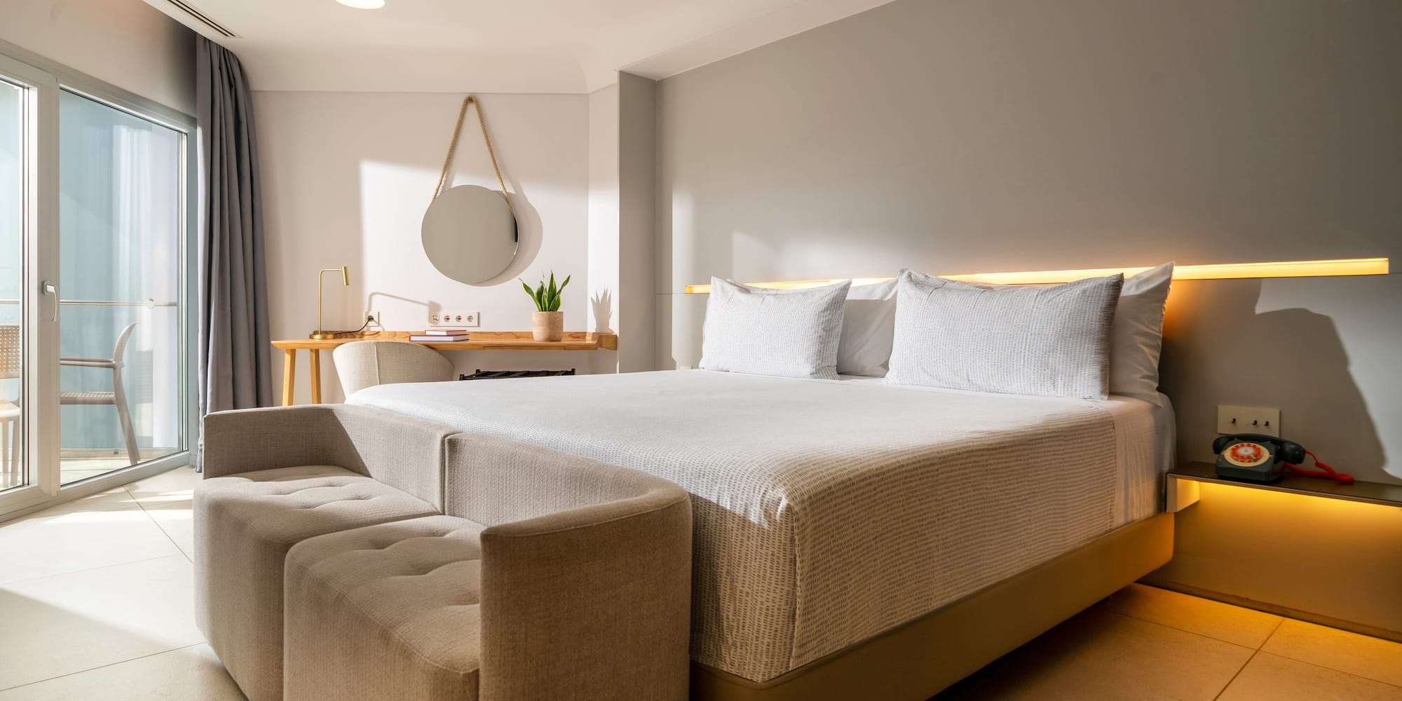 a bed with a couch and a mirror in a room