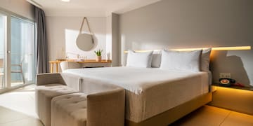 a bed with a couch and a mirror in a room