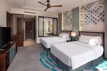 a room with two beds and a fan