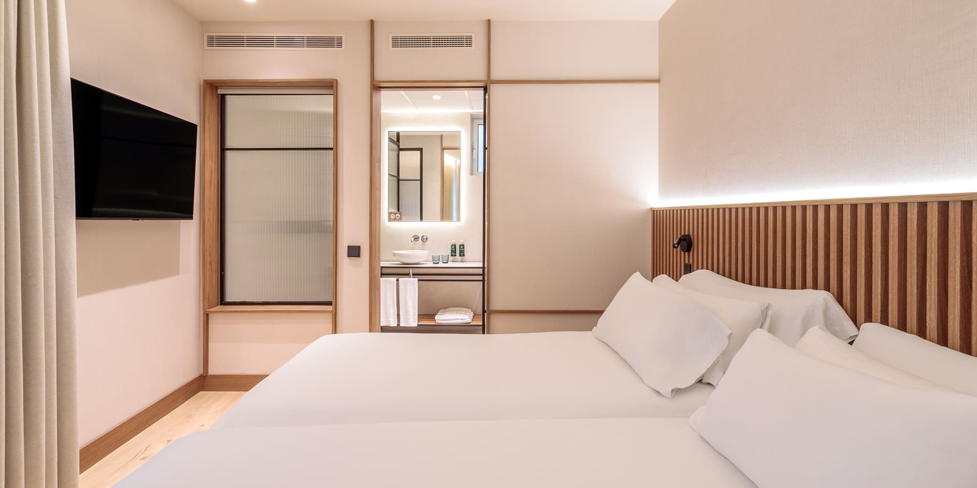 a room with two beds and a television