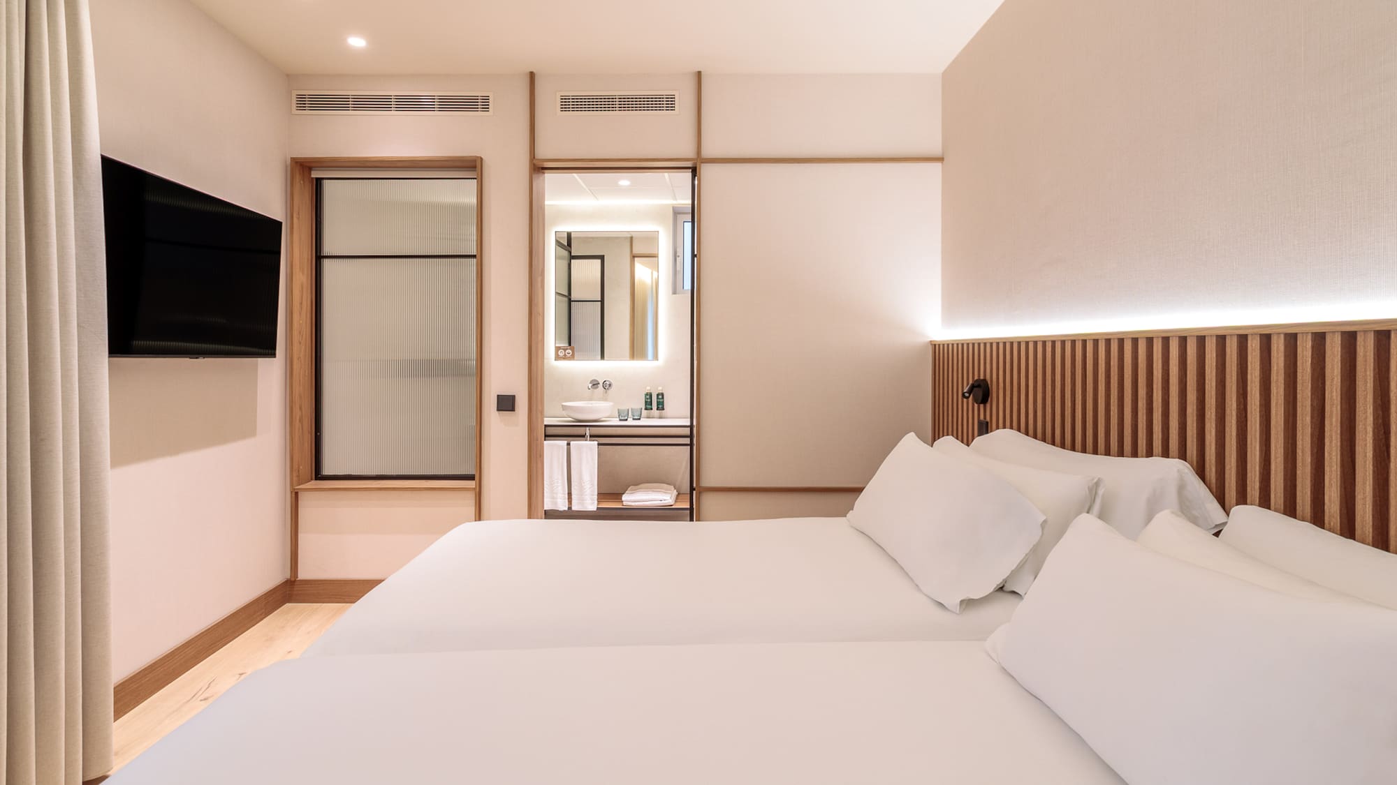 a room with two beds and a television