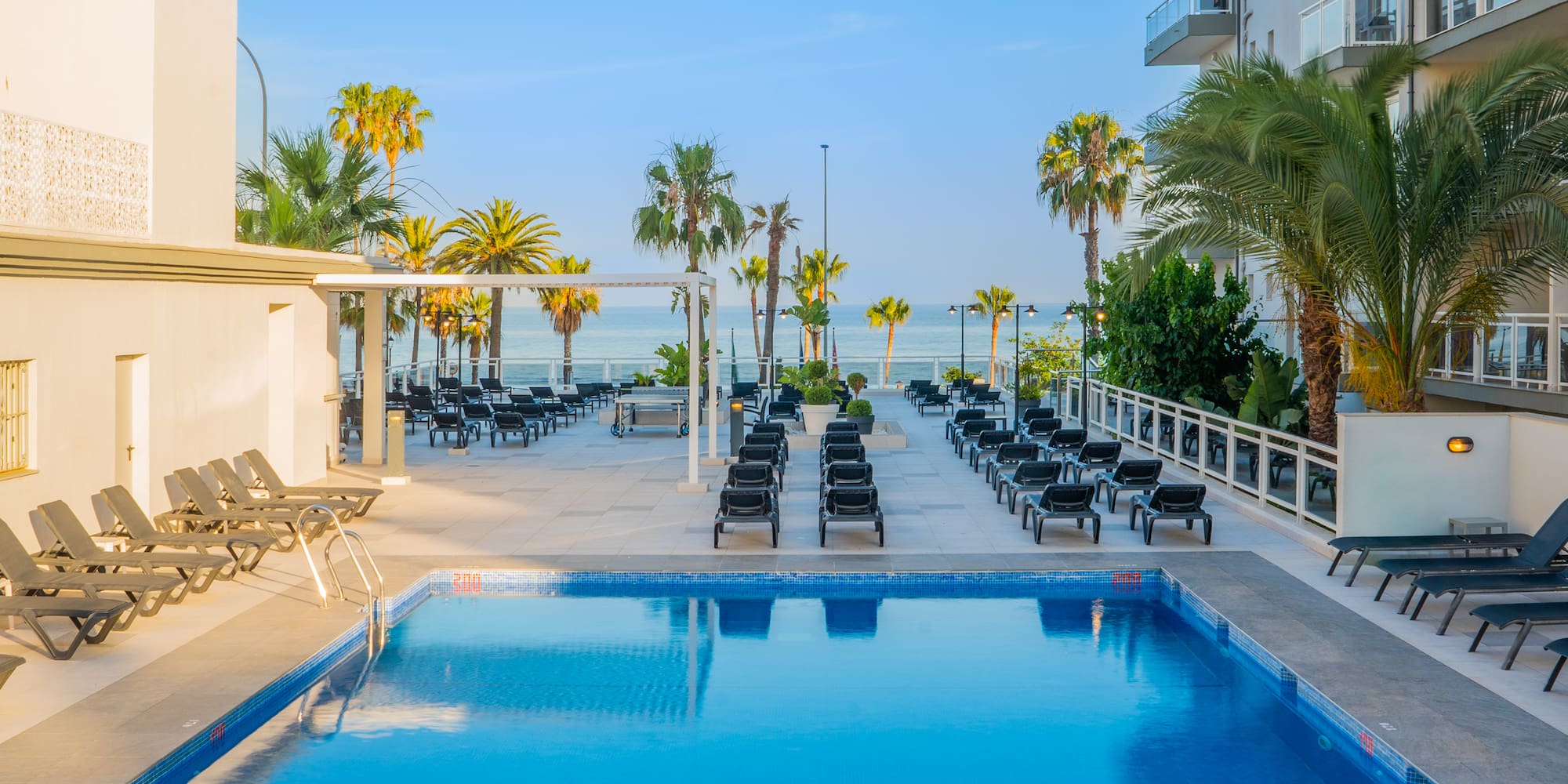 a pool with lounge chairs and palm trees