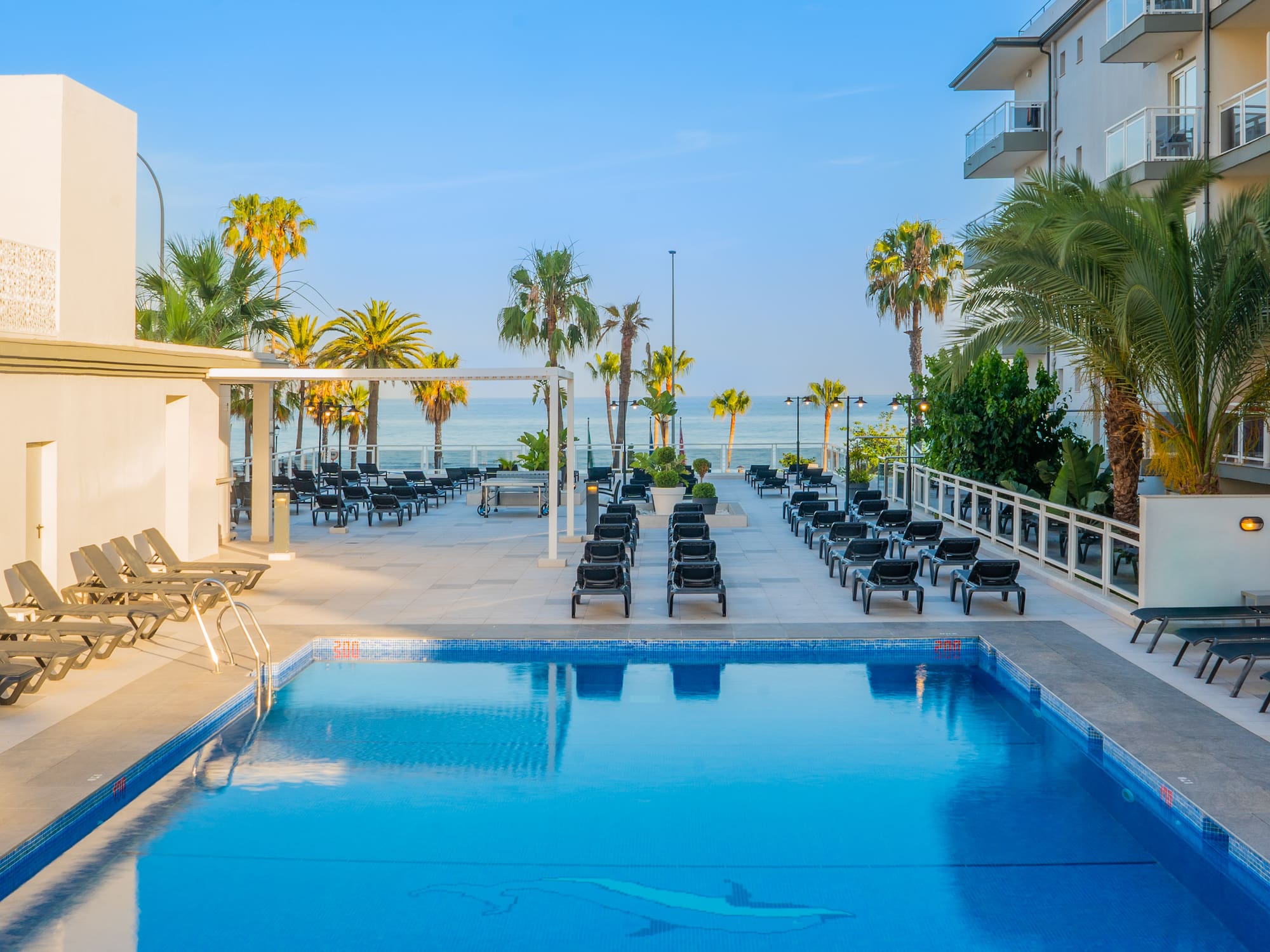 a pool with lounge chairs and palm trees
