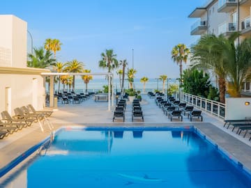 a pool with lounge chairs and palm trees