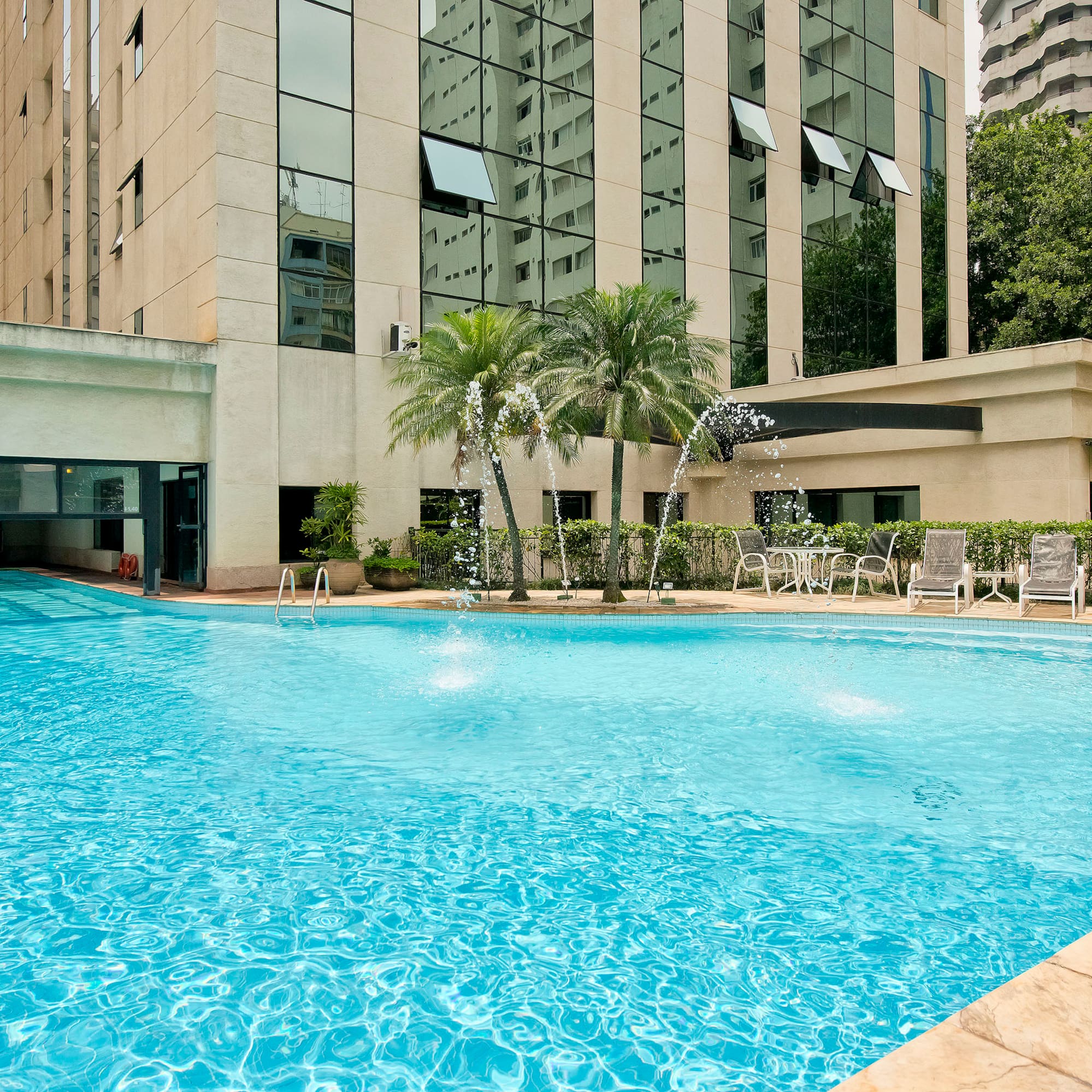 a swimming pool with a fountain in front of a building