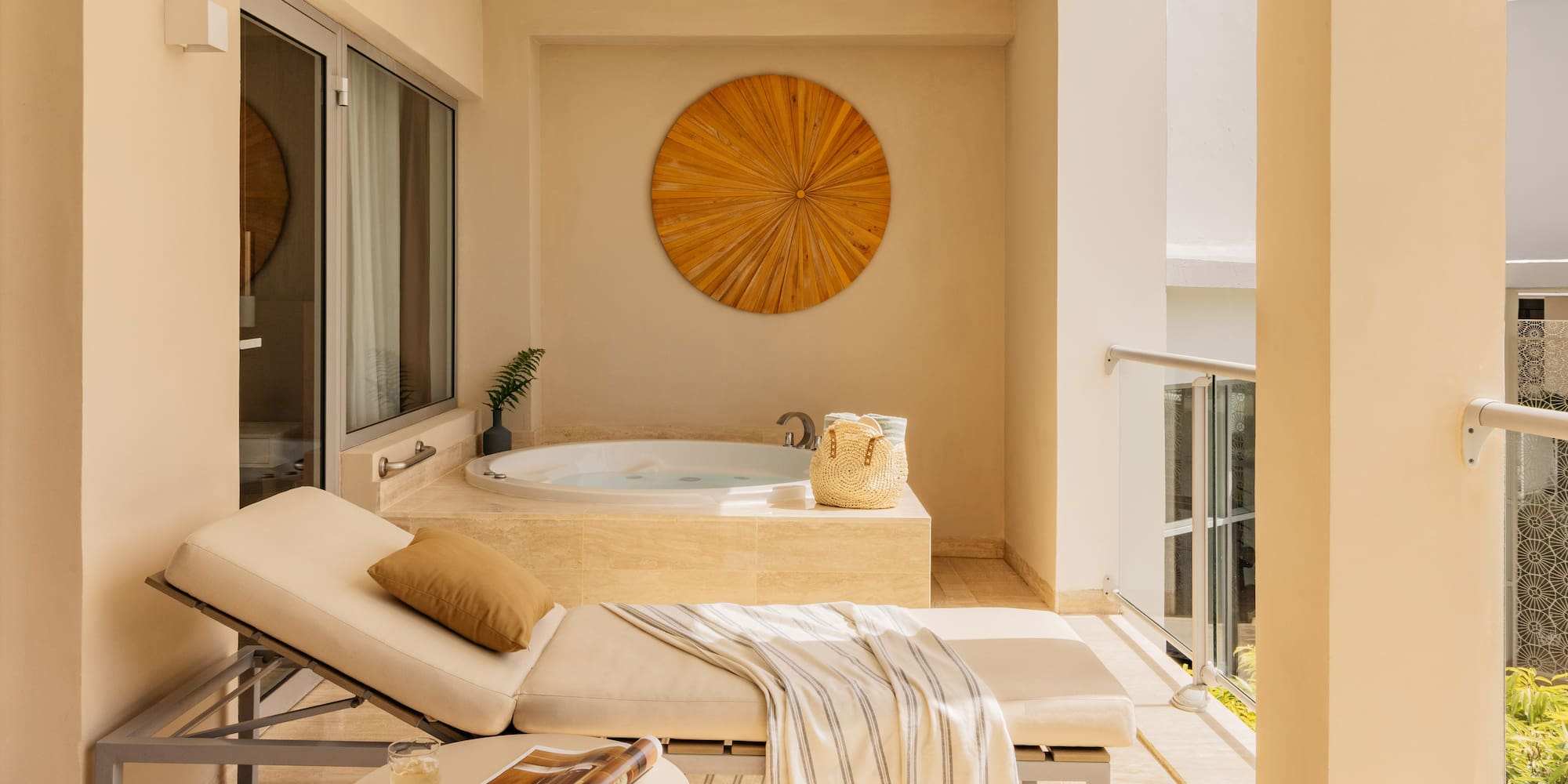 Luxury balcony with outdoor hot tub, daybed, and modern wooden art.