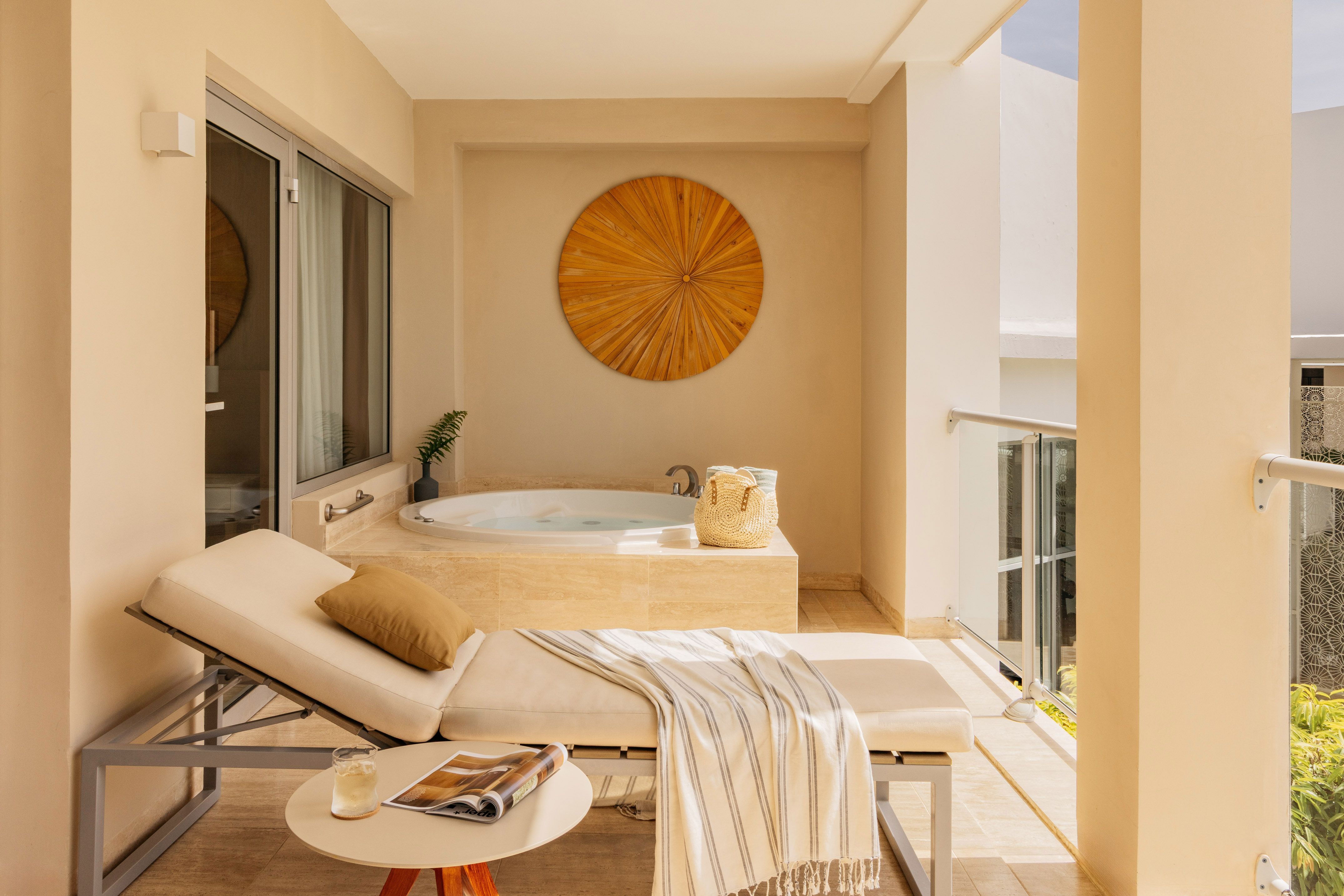 Luxury balcony with outdoor hot tub, daybed, and modern wooden art.
