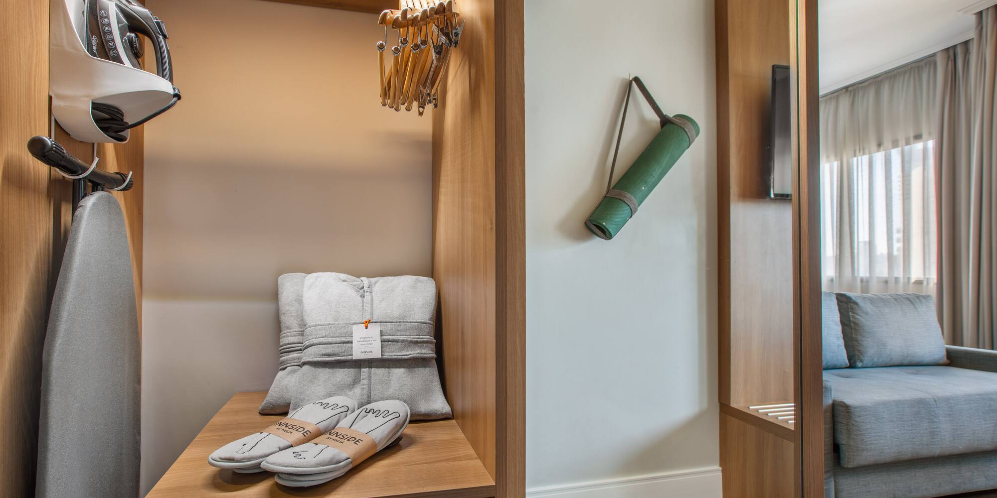 Hotel room amenities: iron, ironing board, yoga mat, slippers, and hangers.