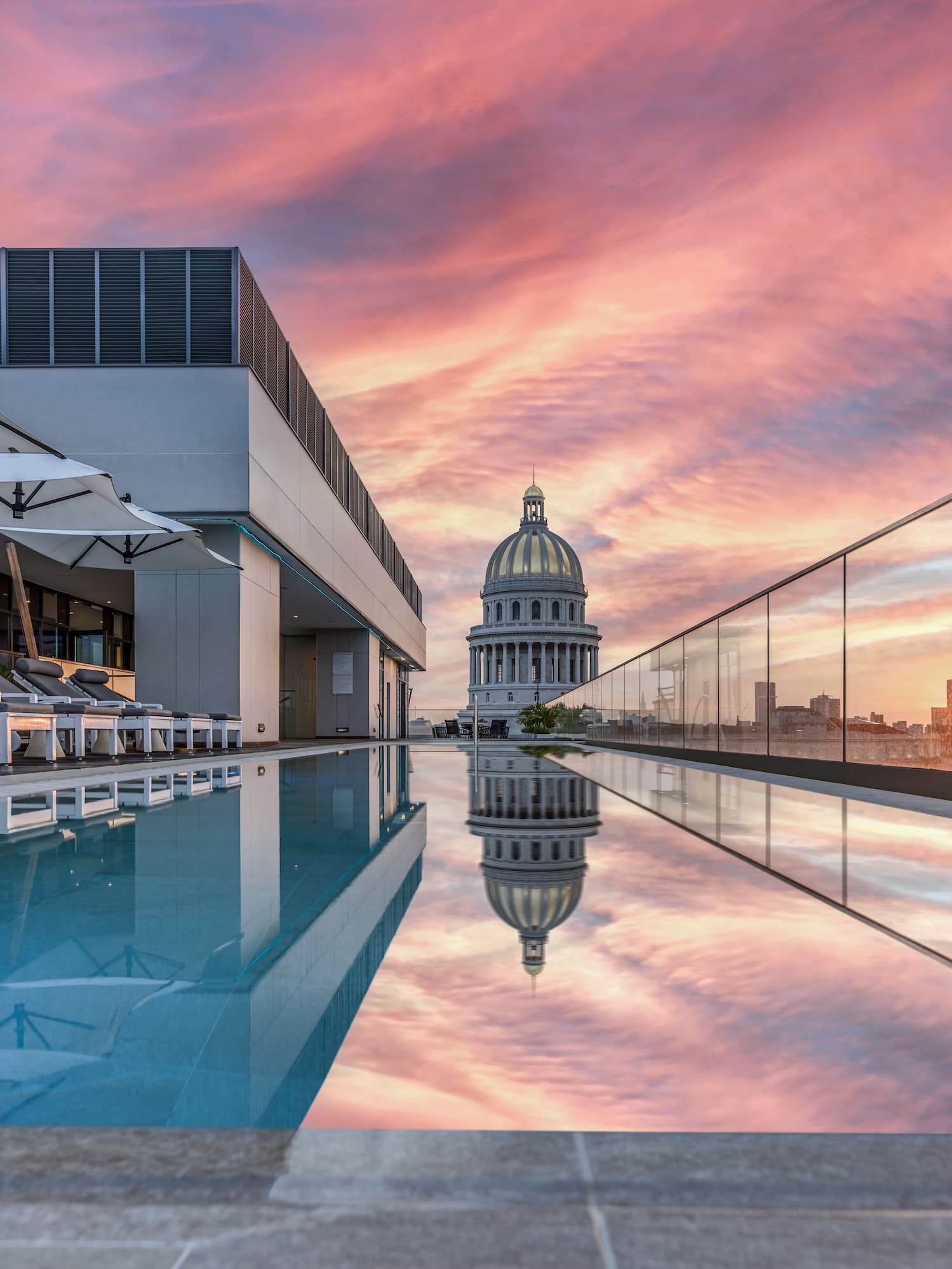 a pool with a building and a city skyline