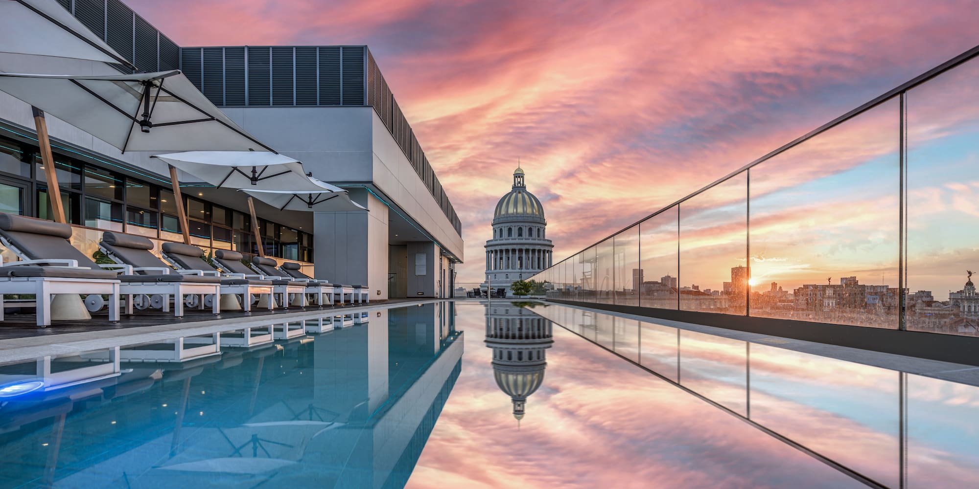 a pool with a building and a city skyline