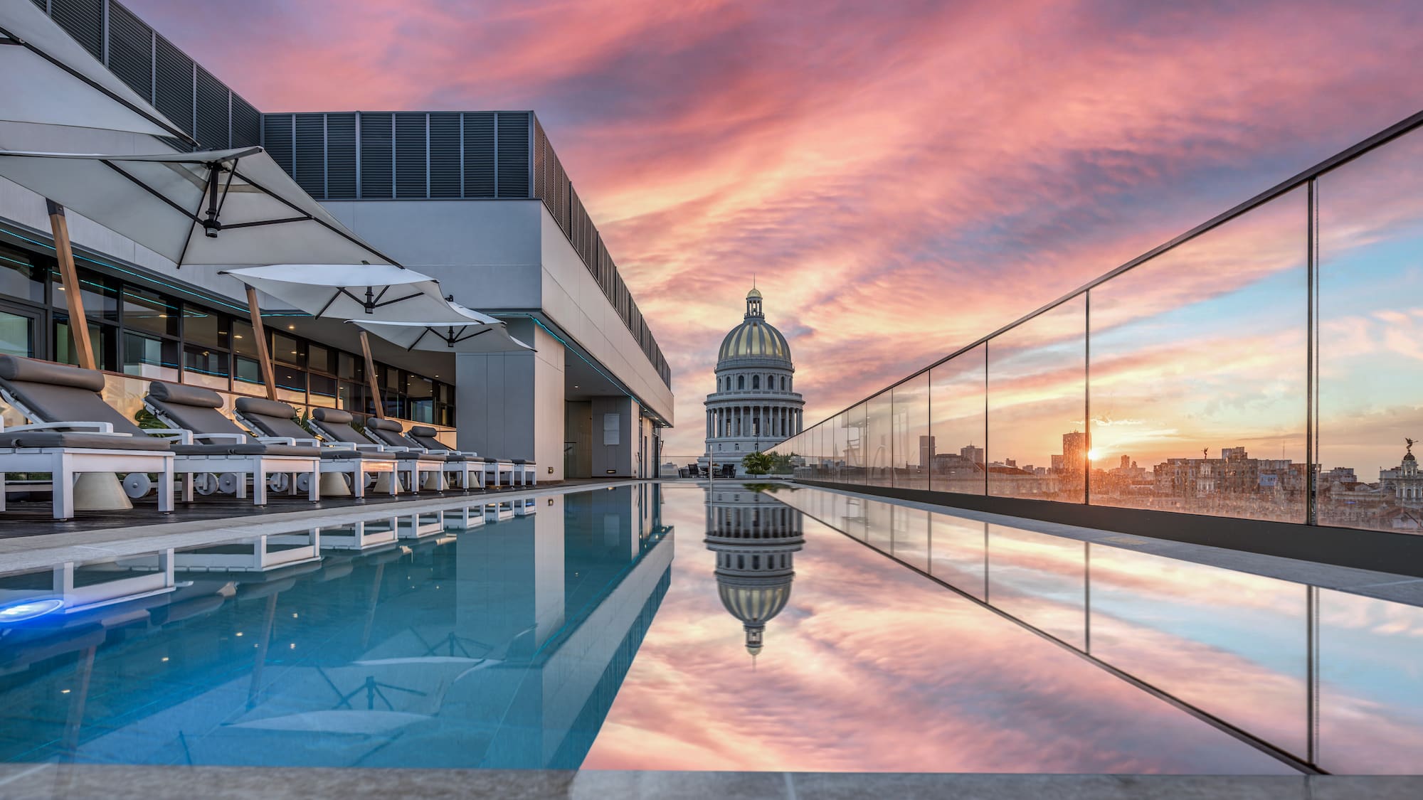 a pool with a building and a city skyline
