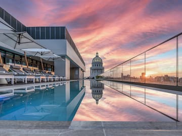 a pool with a building and a city skyline