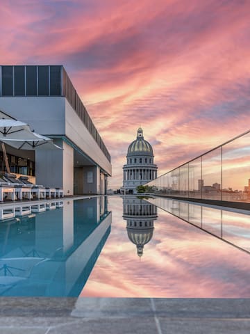 a pool with a building and a city skyline