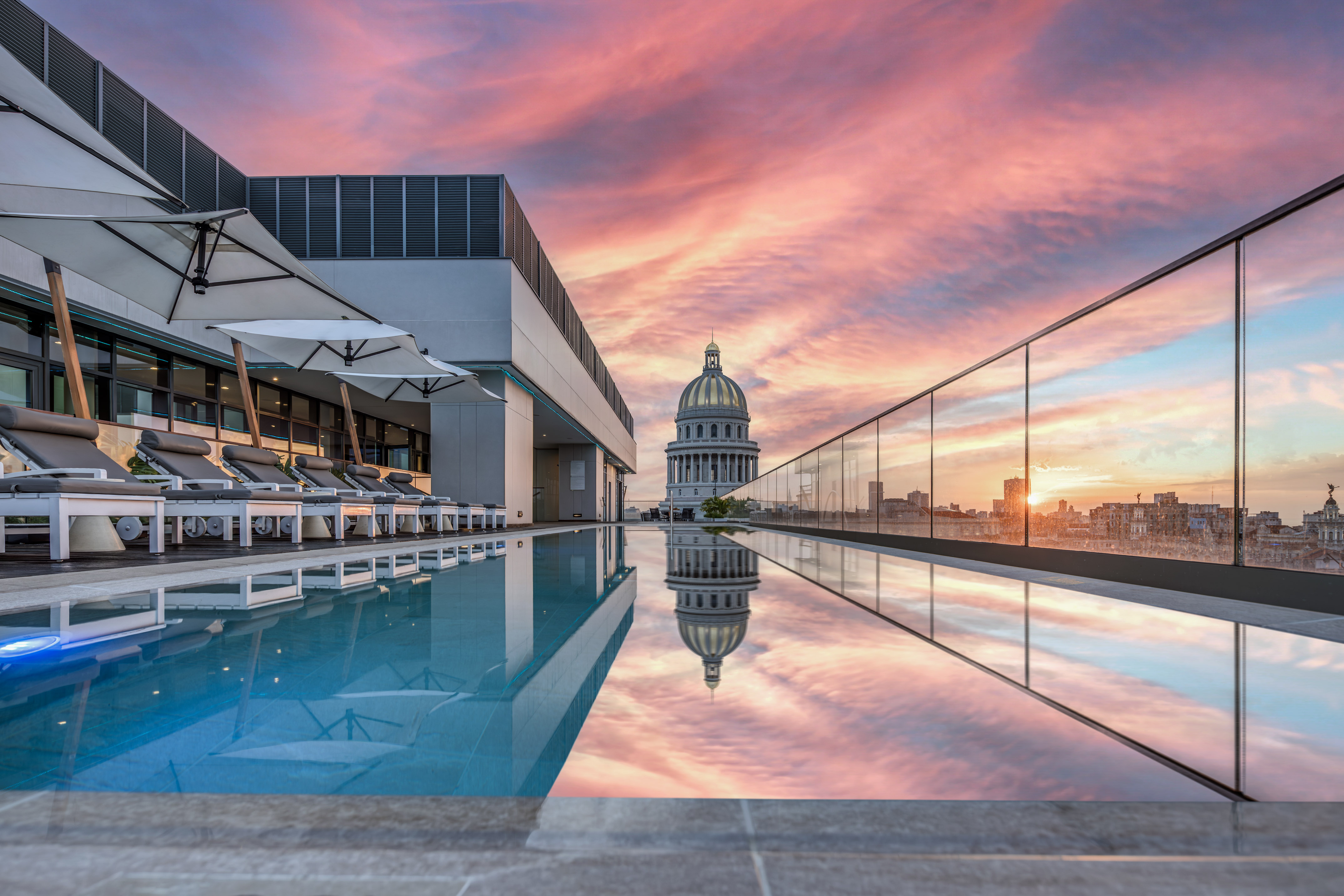 a pool with a building and a city skyline