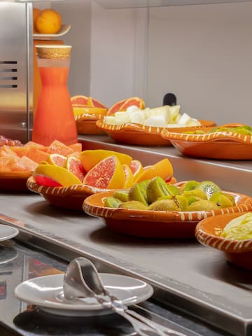 a counter with bowls of fruit and juice