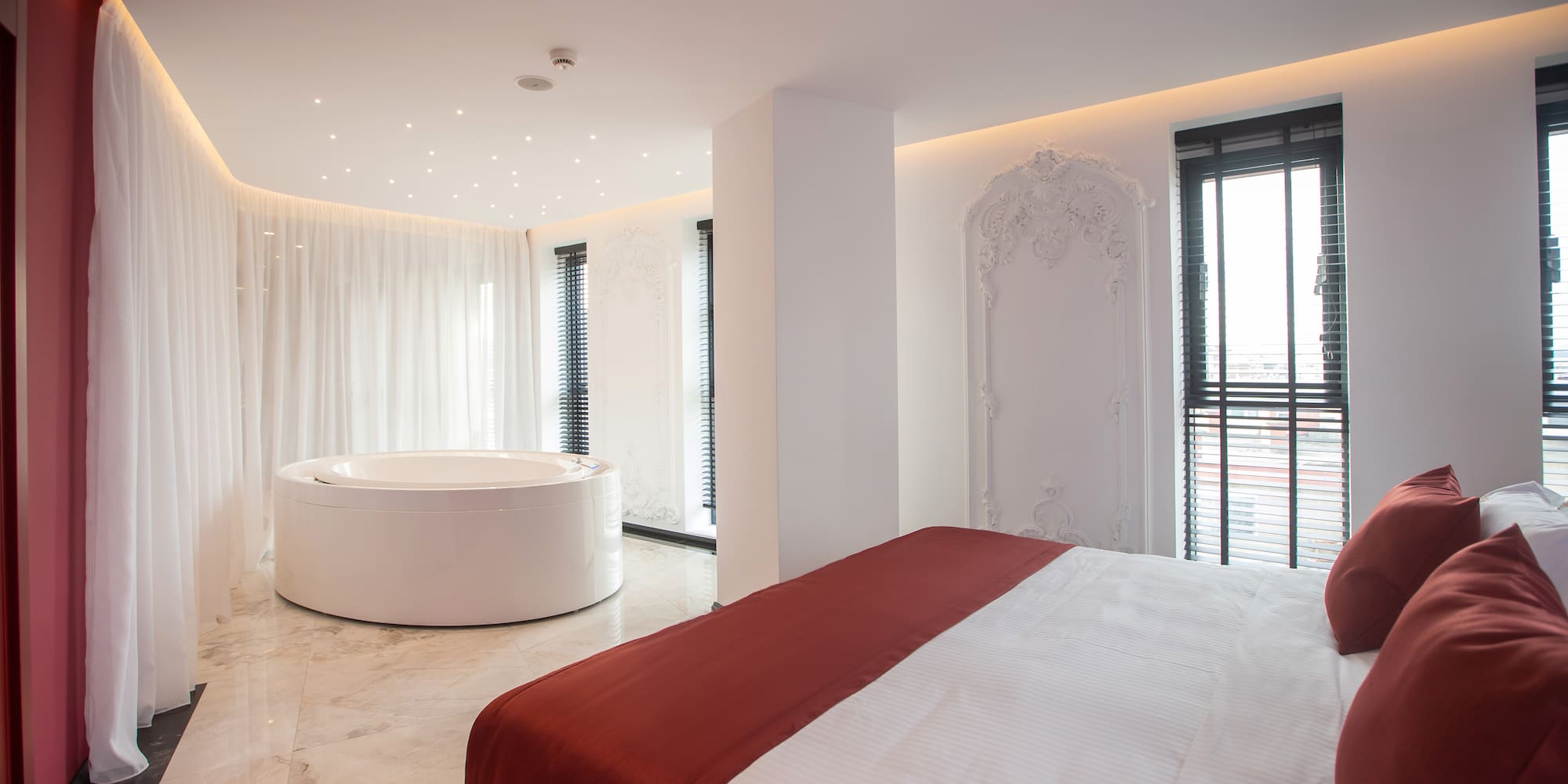 a room with a round tub and a bed