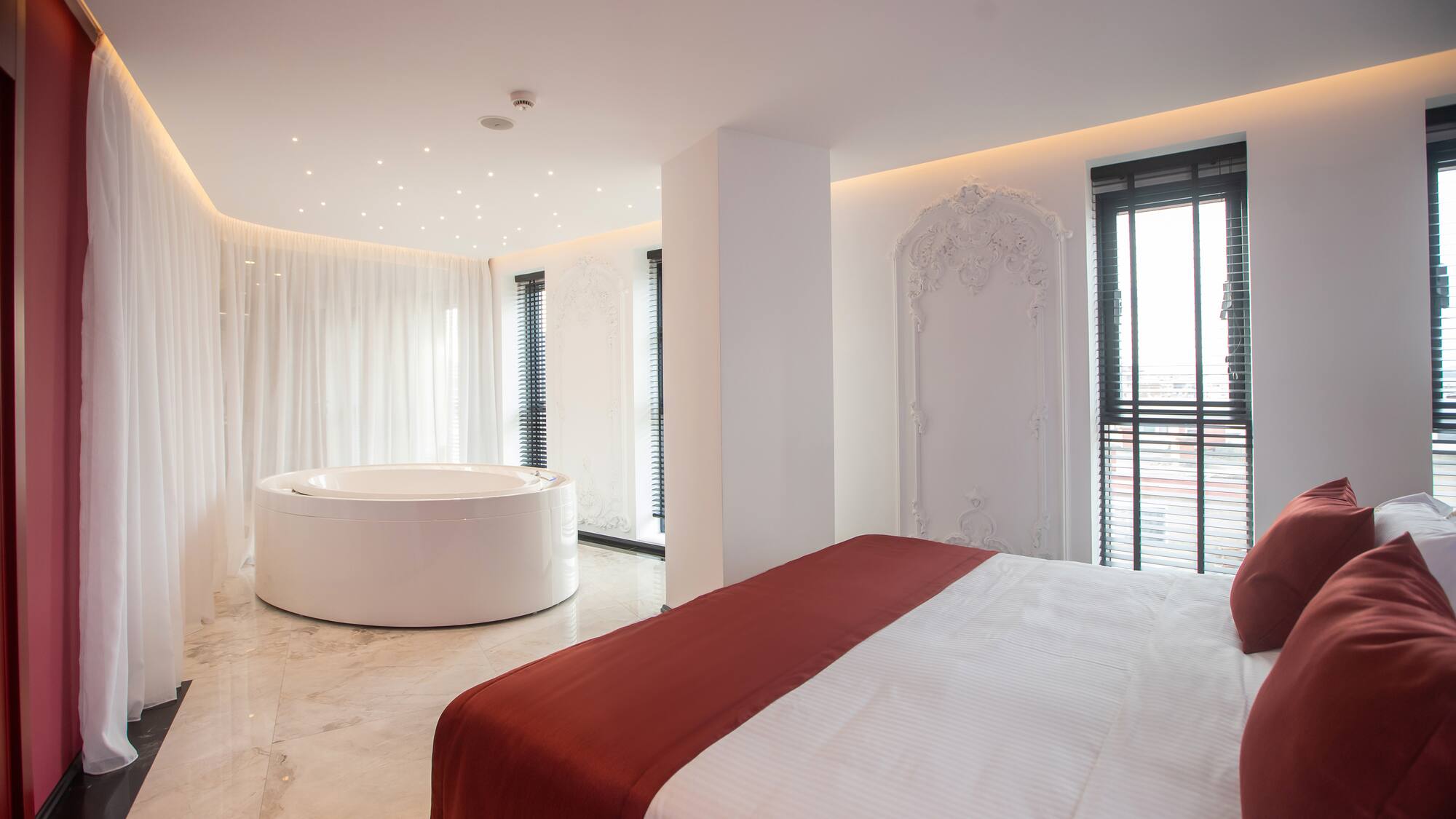 a room with a round tub and a bed