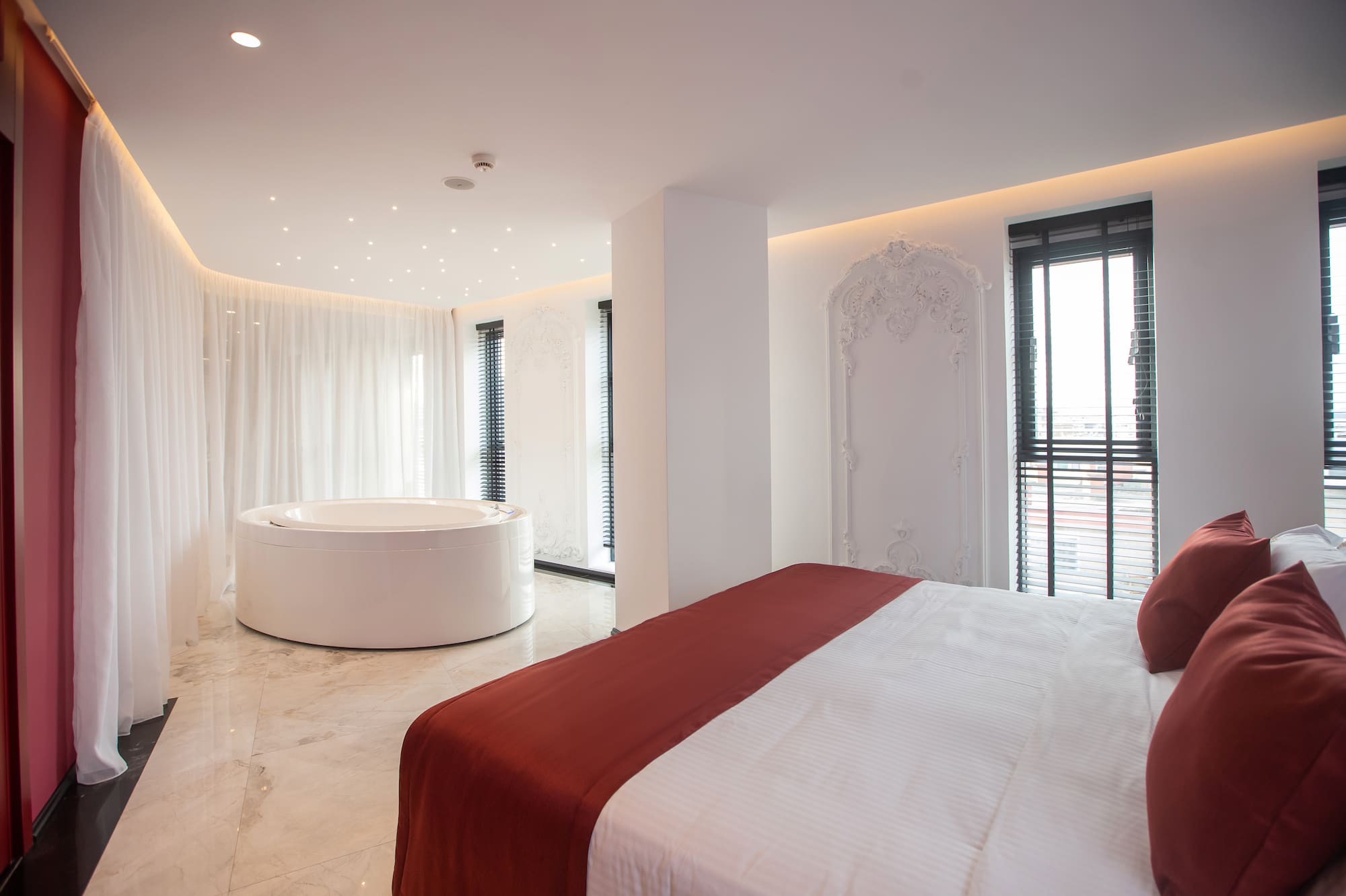 a room with a round tub and a bed