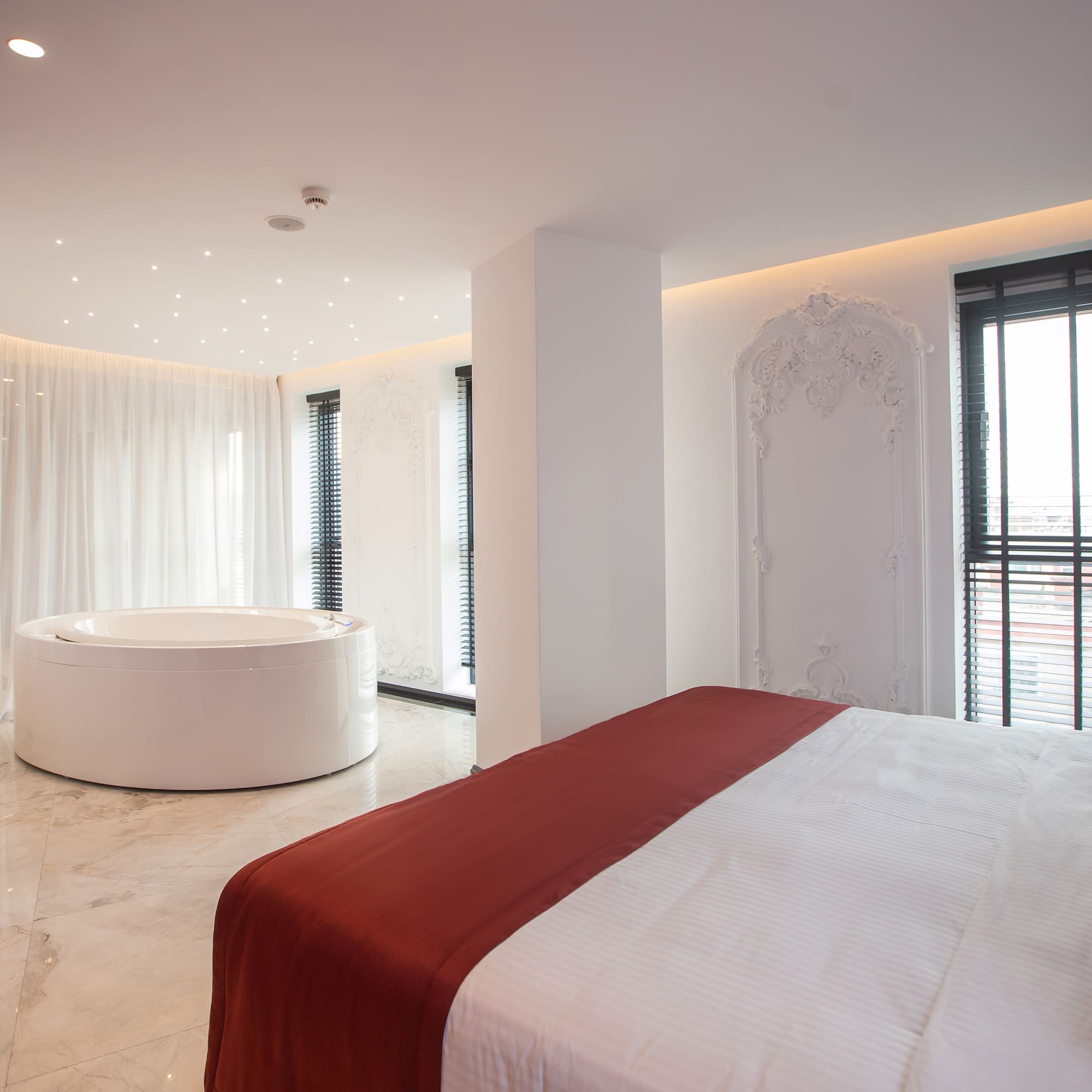 a room with a round tub and a bed