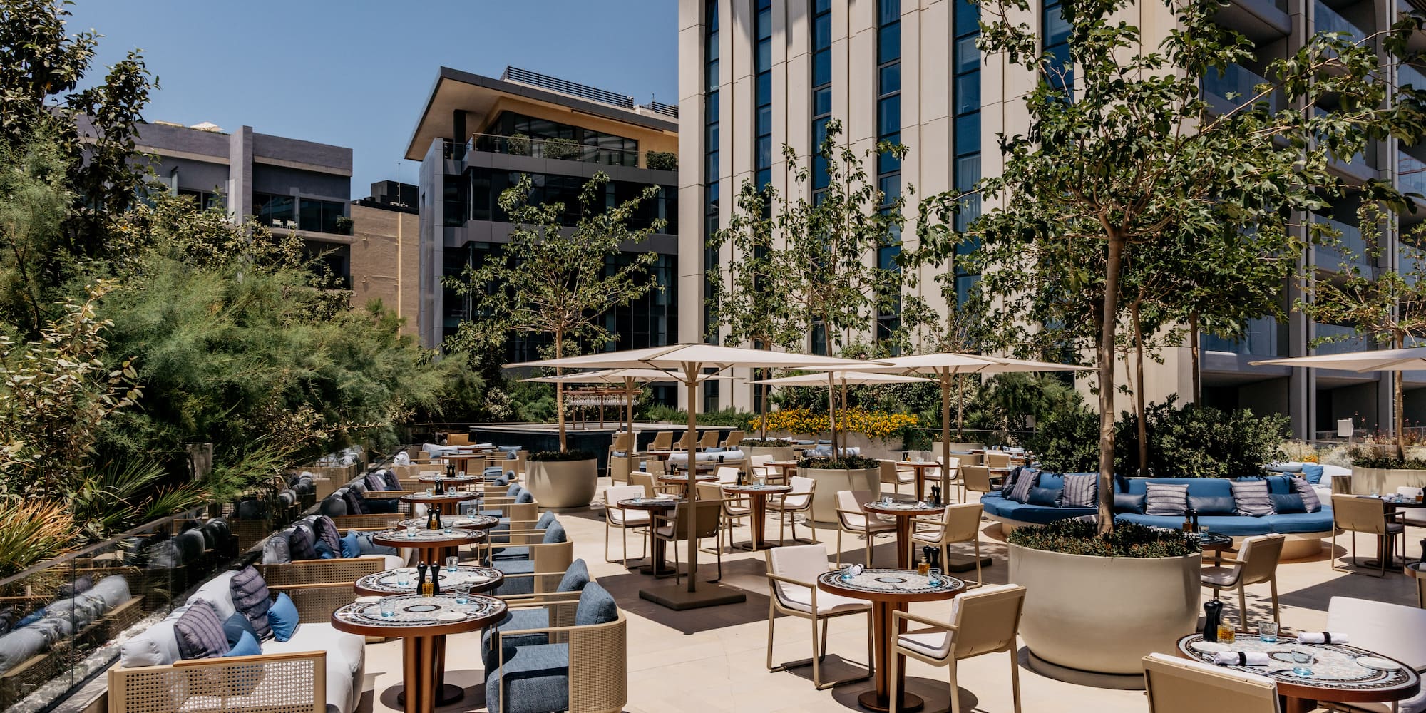 a patio with tables and chairs and trees
