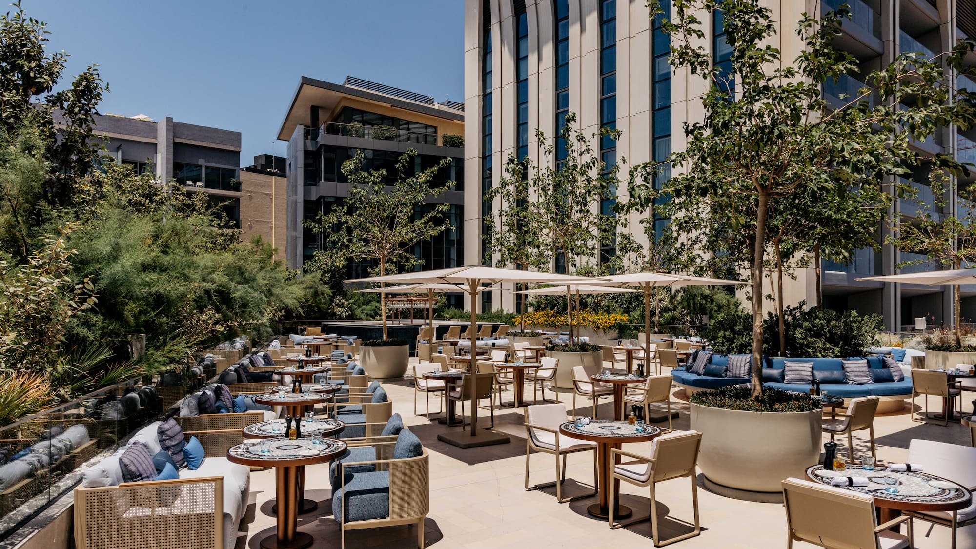 a patio with tables and chairs and trees
