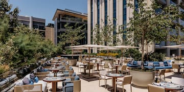 a patio with tables and chairs and trees