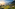Golden terraced rice fields, misty mountains, and houses at sunrise in Vietnam.