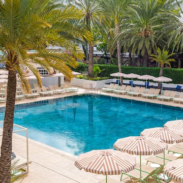 a pool with umbrellas and palm trees
