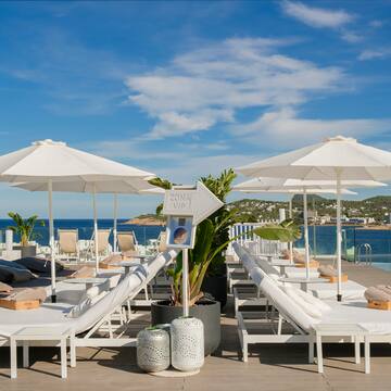 a group of lounge chairs and umbrellas on a deck