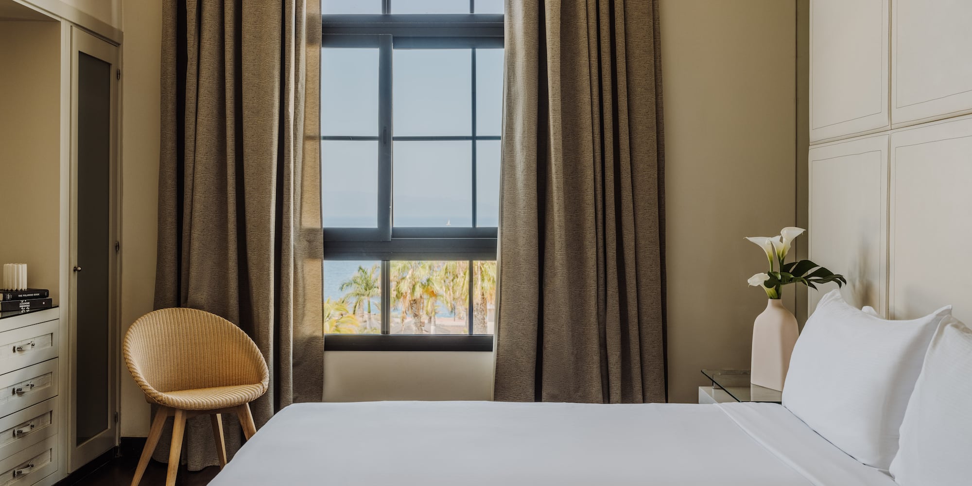 a bed in a room with a chair and a window