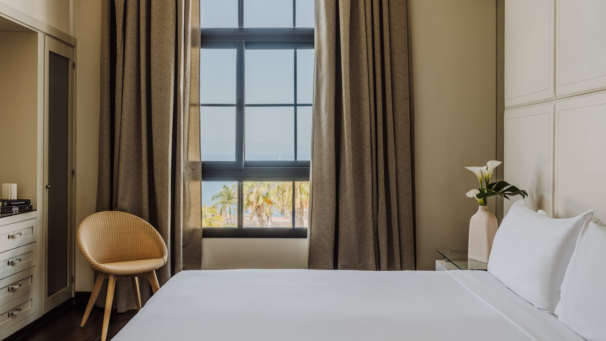 a bed in a room with a chair and a window