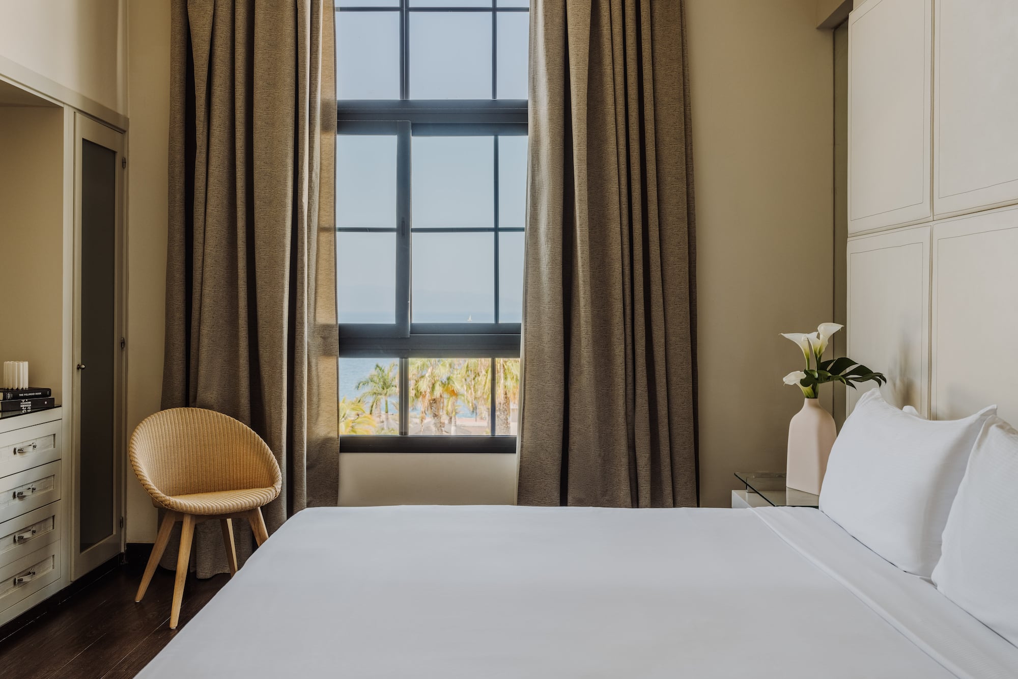 a bed in a room with a chair and a window