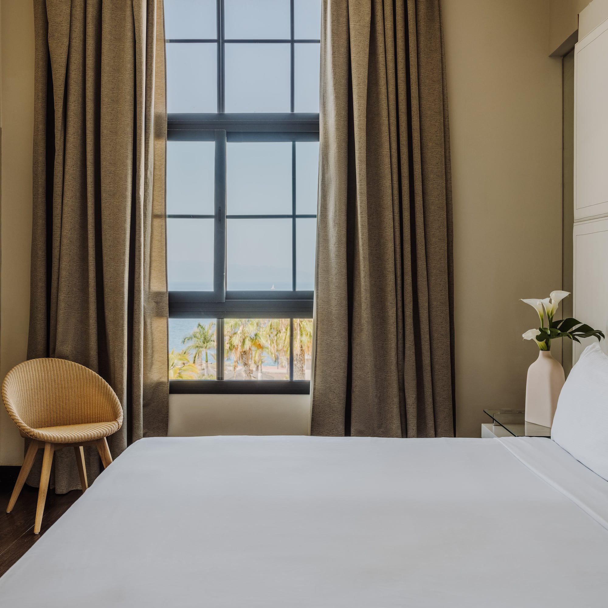 a bed in a room with a chair and a window