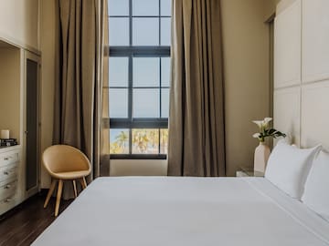 a bed in a room with a chair and a window