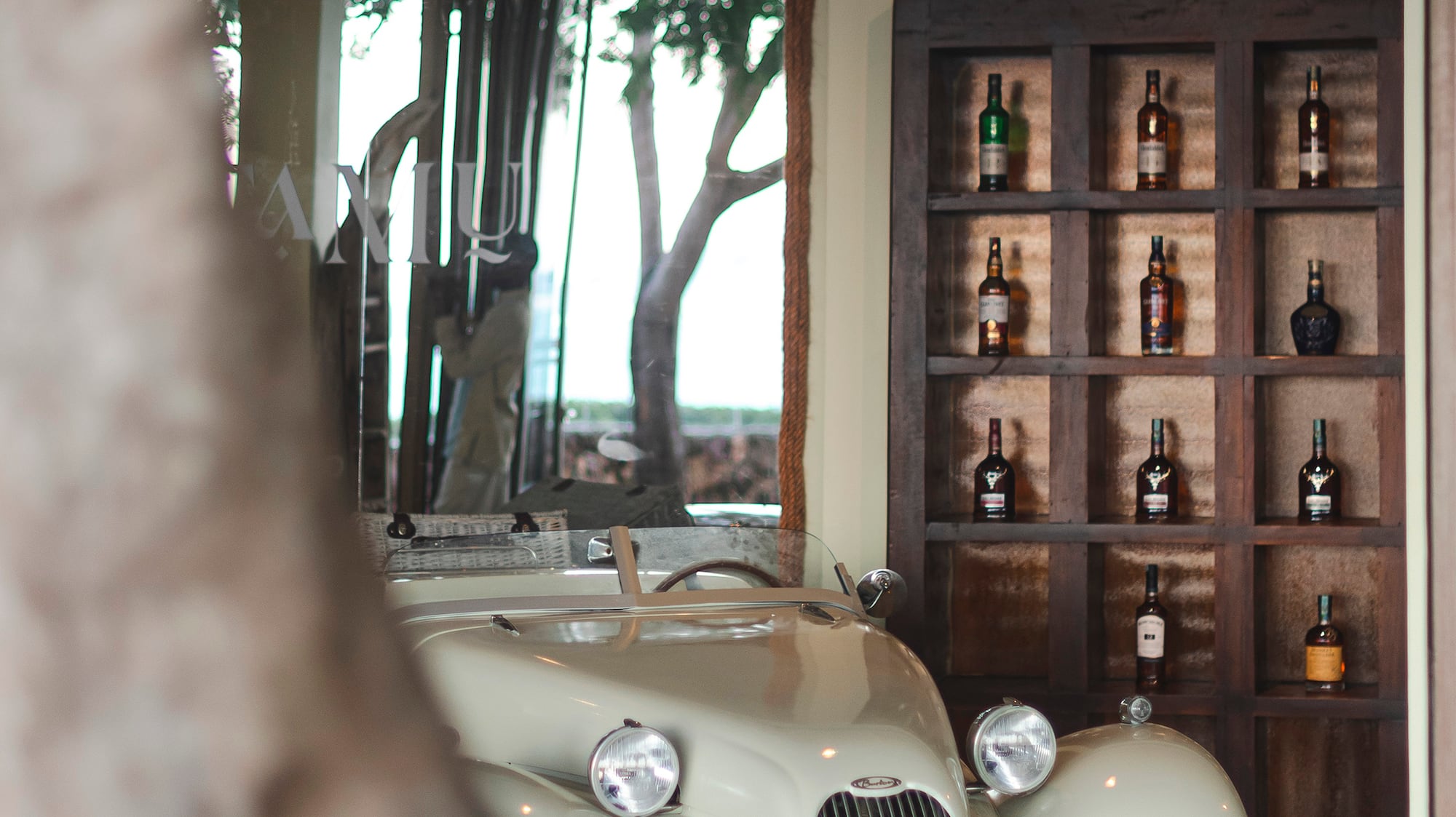 a car parked in a room with bottles on the shelves