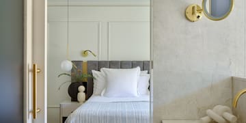 a bed with pillows and a lamp