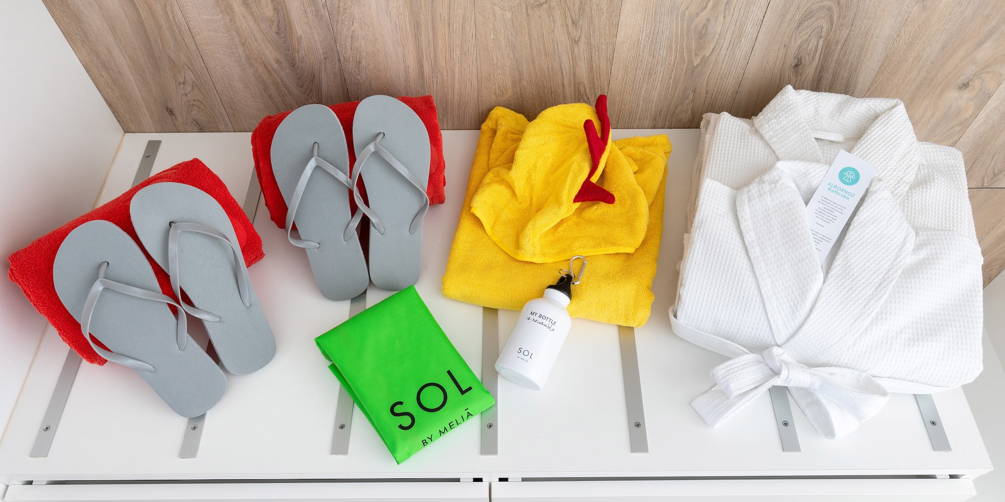 a group of towels and flip flops on a white shelf