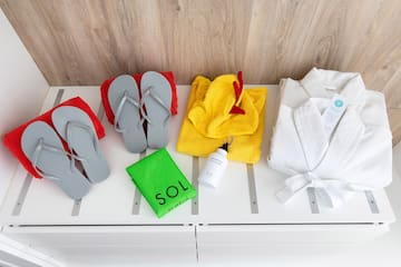 a group of towels and flip flops on a white shelf