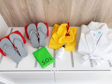 a group of towels and flip flops on a white shelf