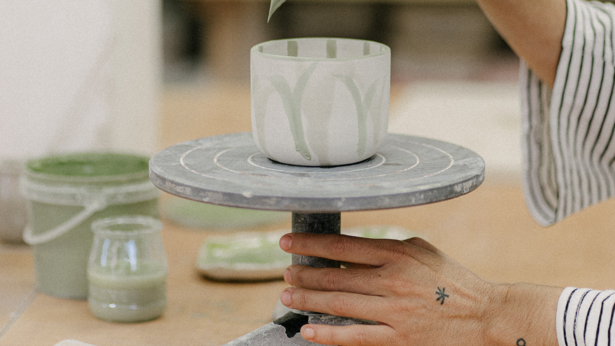 a person painting a cup on a table